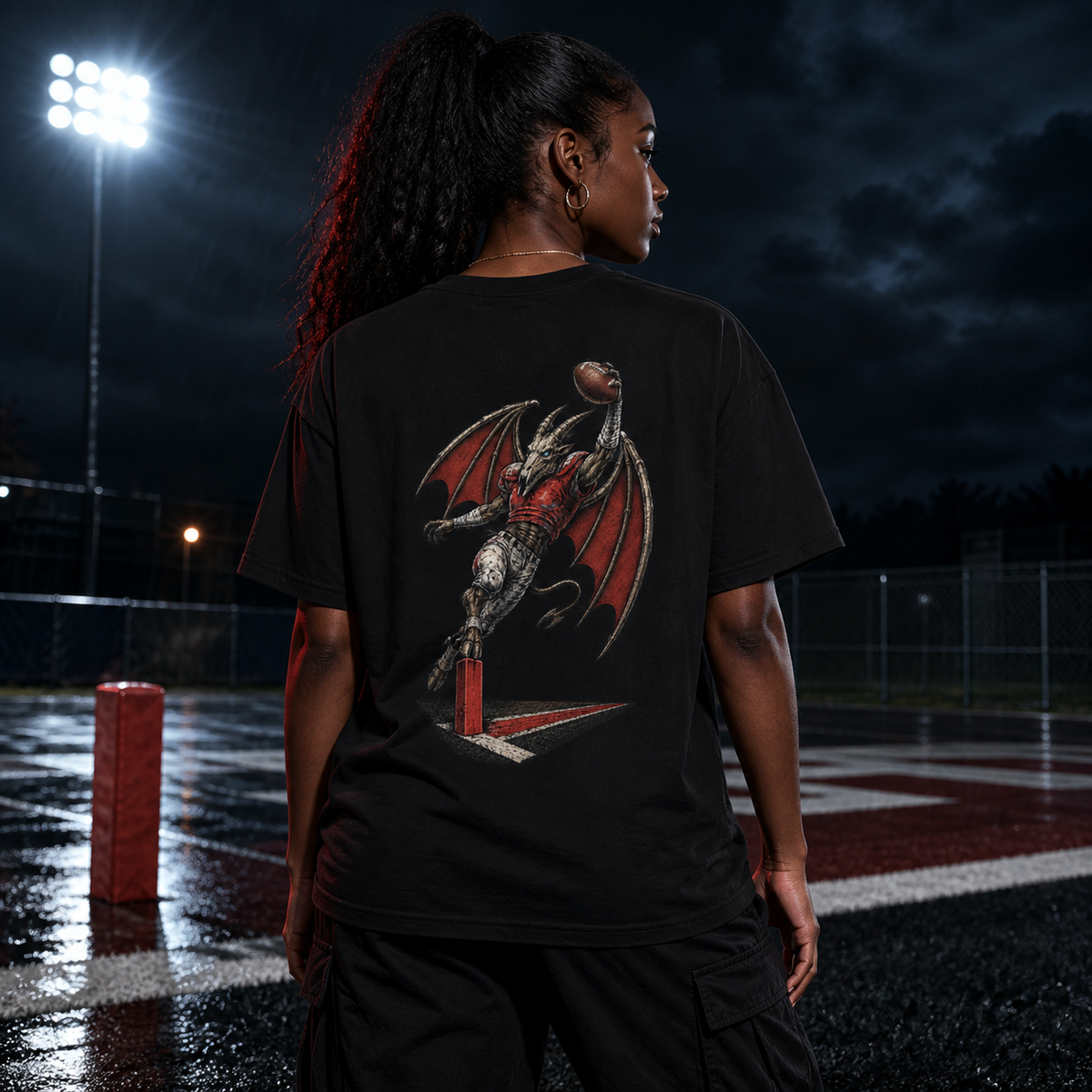 Model wearing the Jersey Devil Red Zone Raider back-print tee in a rain-soaked football end zone